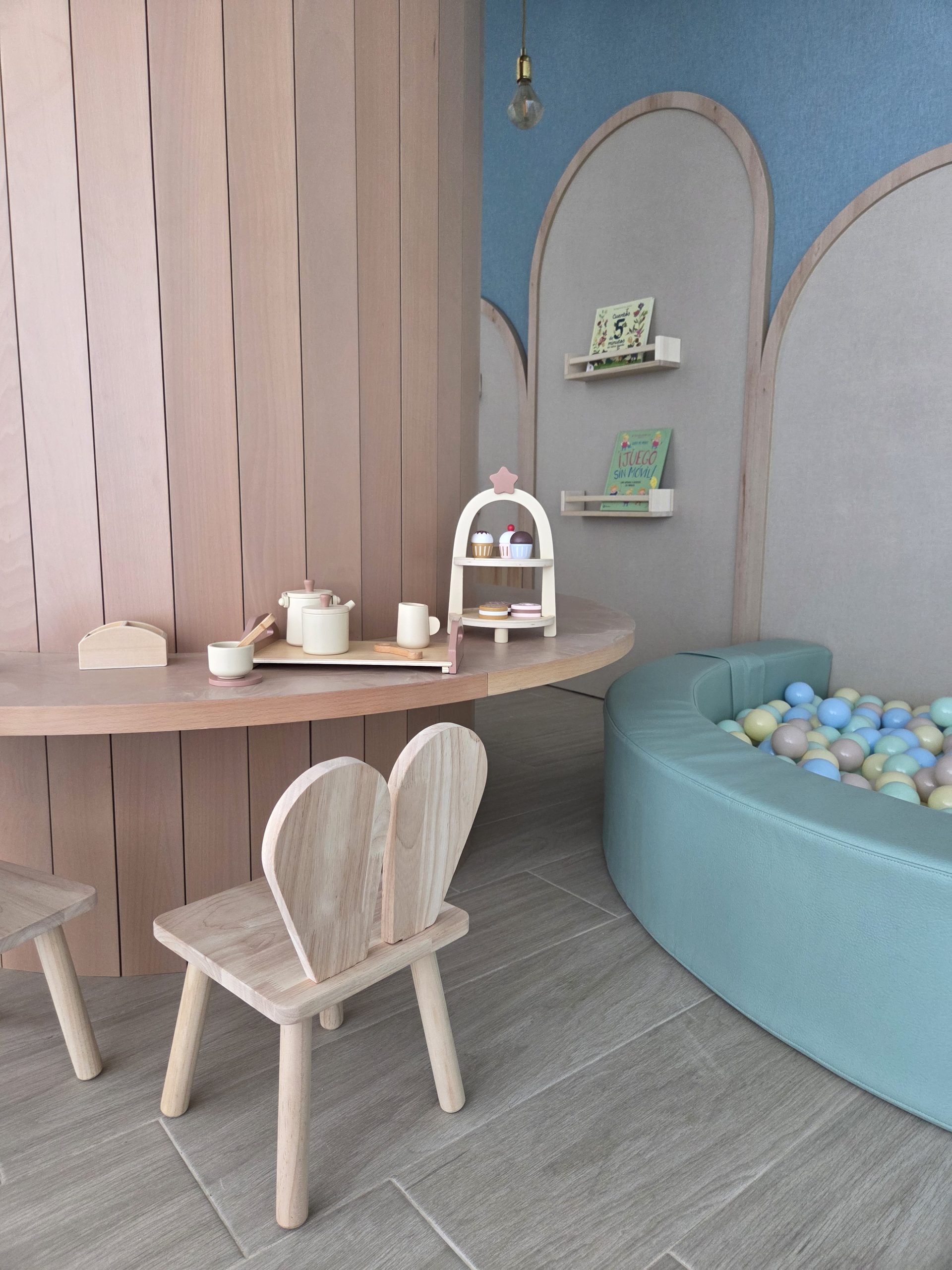 Mesa redonda de madera alrededor del tronco del árbol con sillas infantiles