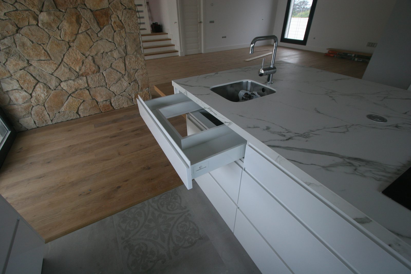 Cocina a medida blanca con isla y encimera de mármol Calacatta, foto de obra