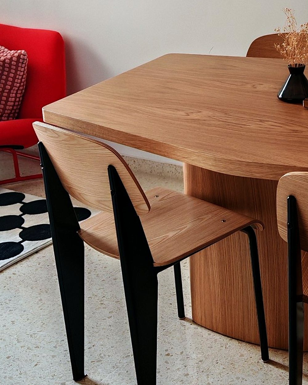 La mesa de roble con sus patas y dos sillas Prouvé en el salón