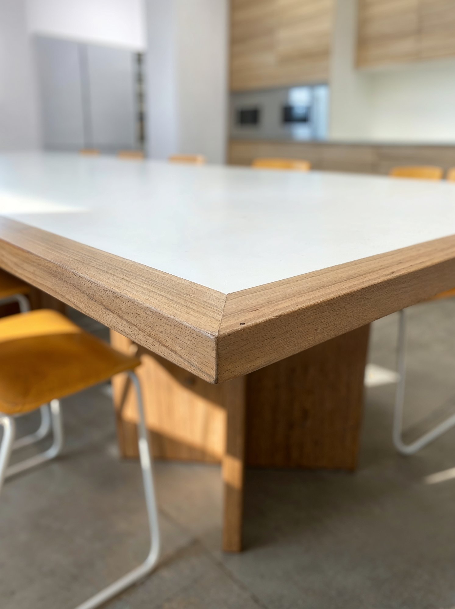 Detalle del canto en acabado madera de la mesa larga